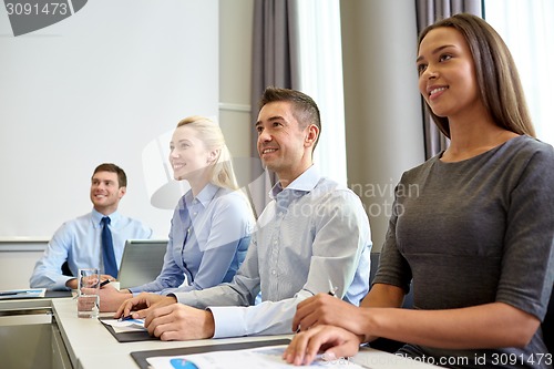 Image of smiling business people meeting in office