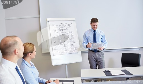 Image of group of smiling businesspeople meeting in office