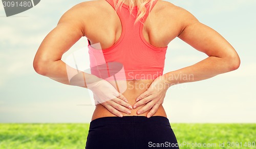 Image of close up of sporty woman touching her back