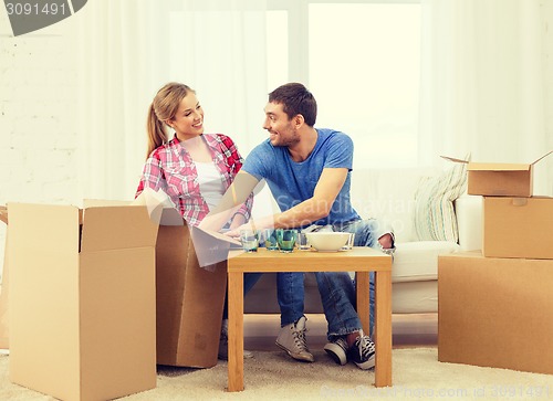 Image of smiling couple unpacking kitchenware