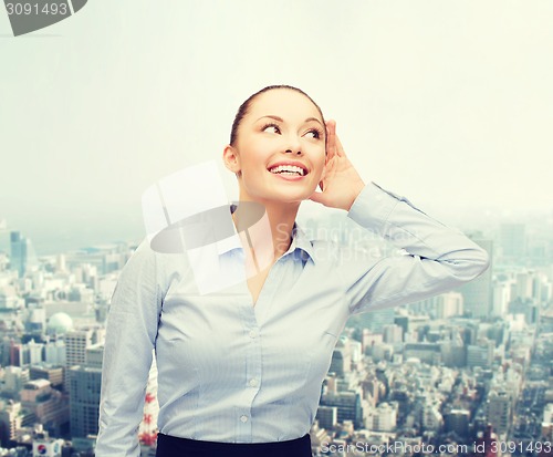 Image of smiling businesswoman listening gossig