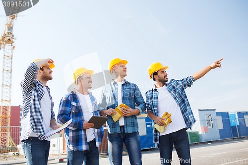 Image of group of smiling builders with tablet pc outdoors