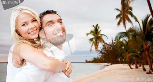 Image of couple having fun and hugging on beach