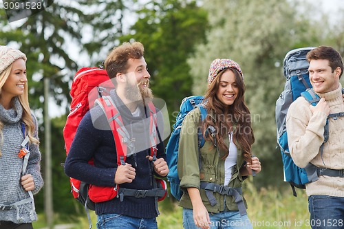 Image of group of smiling friends with backpacks hiking