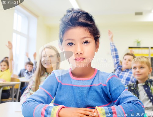 Image of little school girl over classroom background