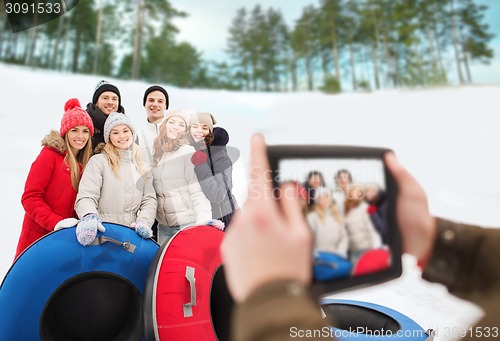 Image of group of smiling friends with snow tubes