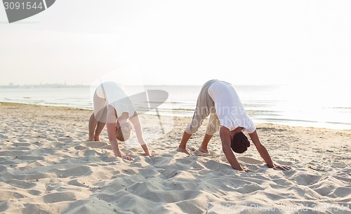 Image of couple making yoga exercises outdoors