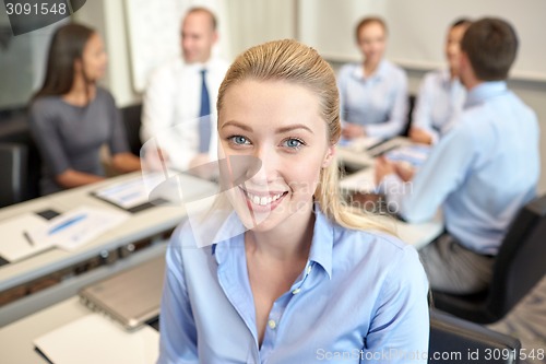 Image of group of smiling businesspeople meeting in office