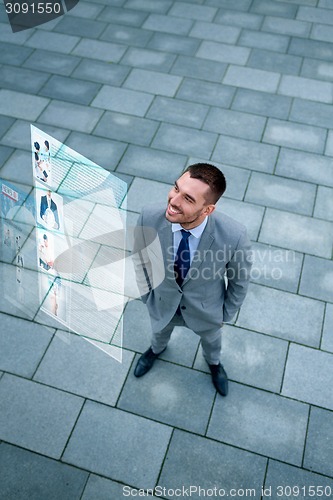 Image of young smiling businessman outdoors from top