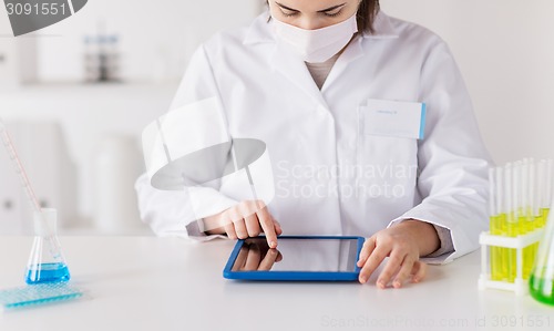 Image of close up of scientist with tablet pc in laboratory