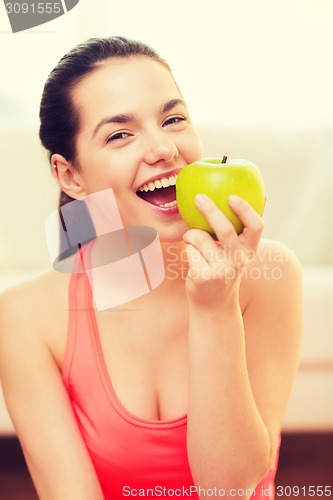 Image of smiling teenage girl with green apple at home