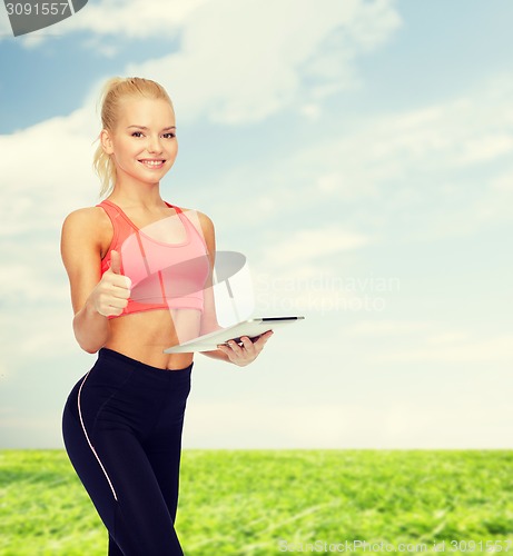 Image of smiling sporty woman with tablet pc computer