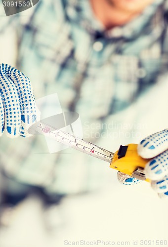 Image of architect measuring wall with flexible ruler