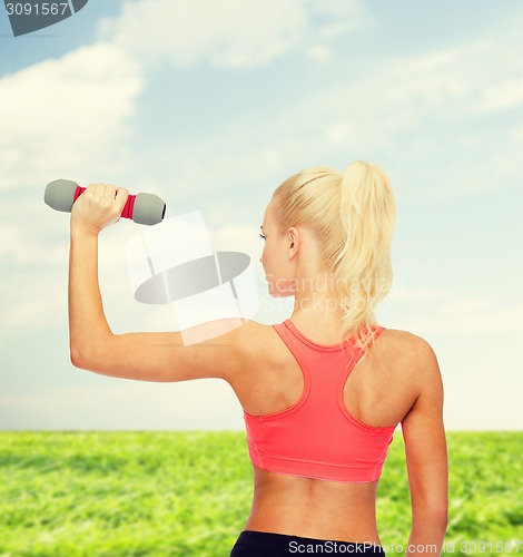 Image of young sporty woman with light dumbbell