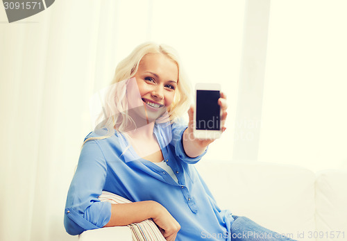Image of smiling woman with blank smartphone screen at home