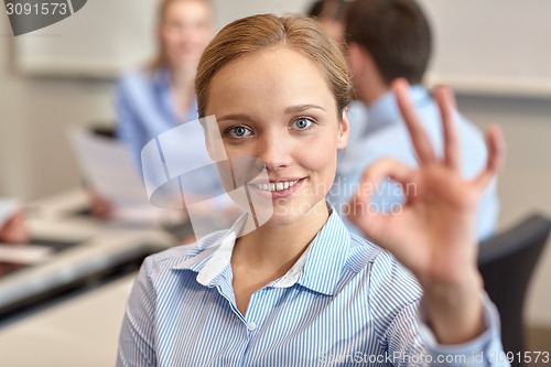 Image of group of smiling businesspeople meeting in office