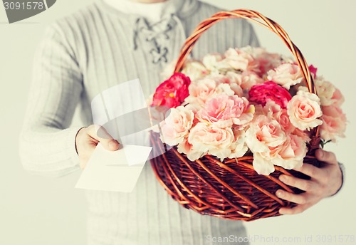 Image of man holding basket full of flowers and postcard