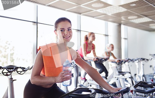 Image of group of women riding on exercise bike in gym