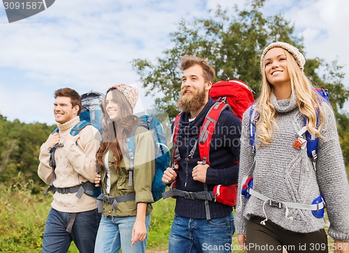 Image of group of smiling friends with backpacks hiking