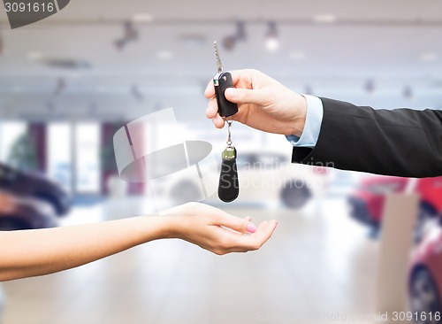 Image of close up of customer and salesman with car key