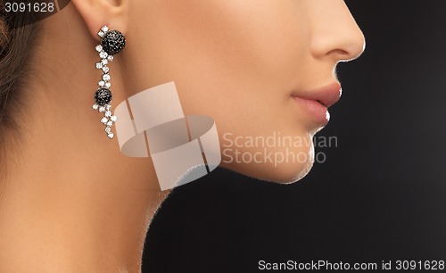 Image of woman wearing shiny diamond earrings