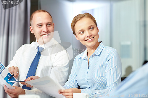 Image of business people with papers meeting in office