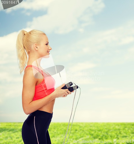 Image of smiling sporty woman with skipping rope