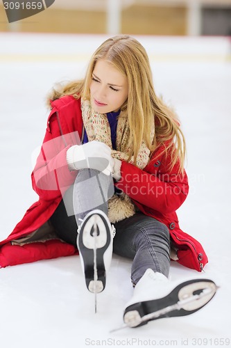 Image of young woman fell down on skating rink