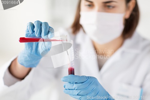 Image of close up of scientist with tube making test in lab