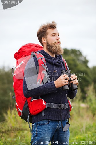 Image of man with backpack and binocular outdoors