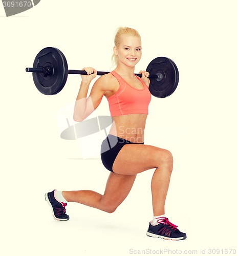 Image of smiling sporty woman exercising with barbell