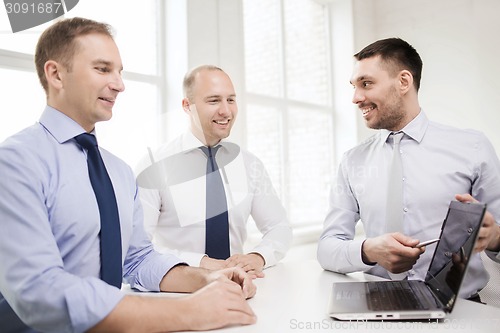 Image of smiling businessmen having discussion in office