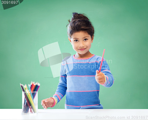 Image of happy school girl drawing with coloring pencils