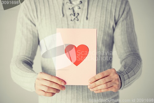 Image of man holding postcard with heart shape