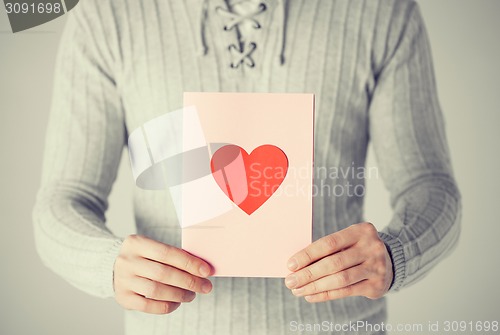 Image of man holding postcard with heart shape