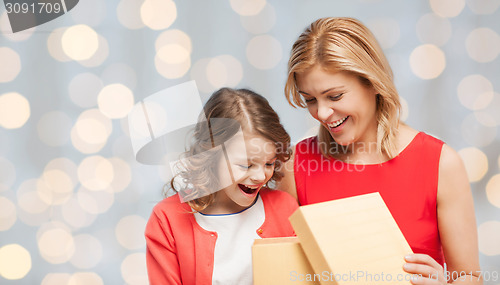 Image of happy mother and daughter opening gift box