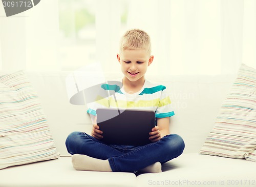 Image of smiling boy with tablet computer at home