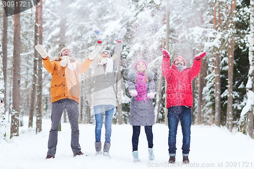 Image of group of happy friends playin with snow in forest