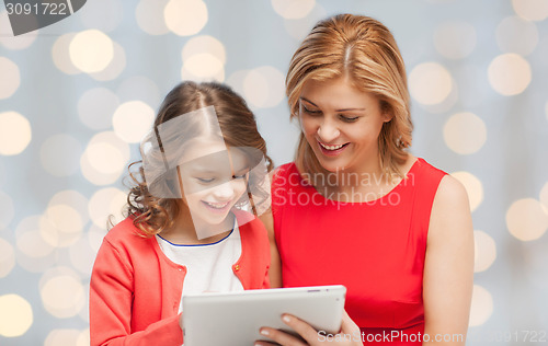 Image of mother and daughter with tablet pc over green