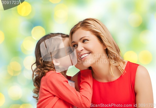 Image of happy daughter whispering gossip to her mother