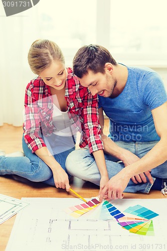 Image of smiling couple looking at color samples at home