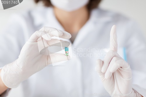 Image of close up of scientist holding pill in lab