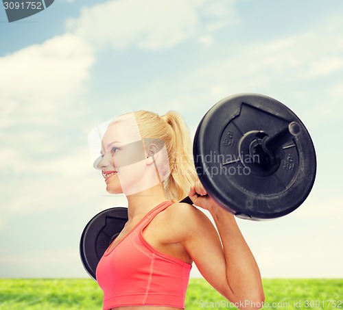 Image of smiling sporty woman exercising with barbell