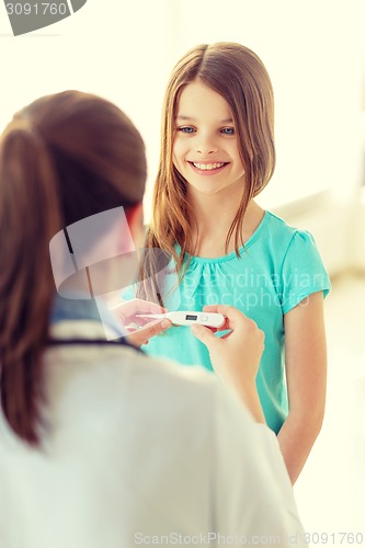 Image of female doctor with child measuring temperature