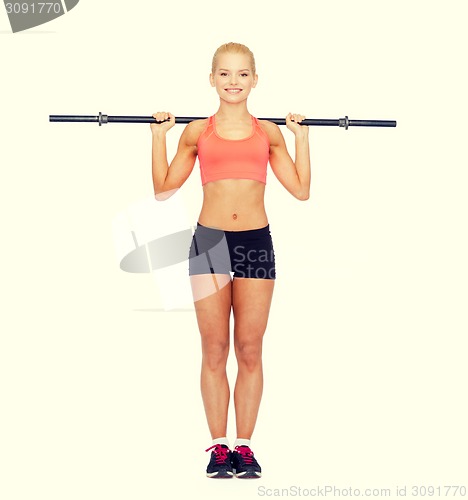 Image of smiling sporty woman exercising with barbell