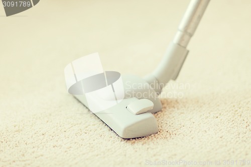 Image of close up of male hoovering carpet