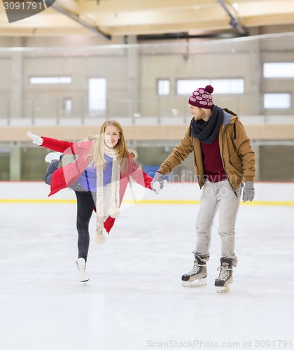 Image of happy couple holding hands on skating rink