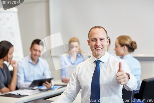 Image of group of smiling businesspeople meeting in office