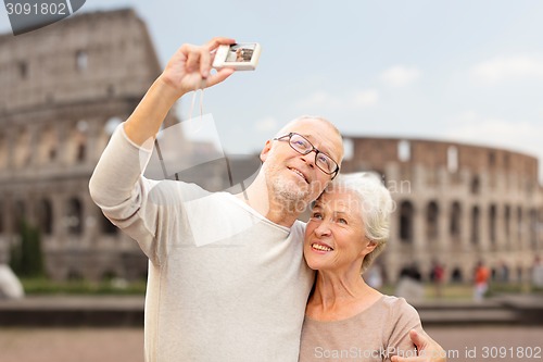 Image of senior couple photographing over coliseum