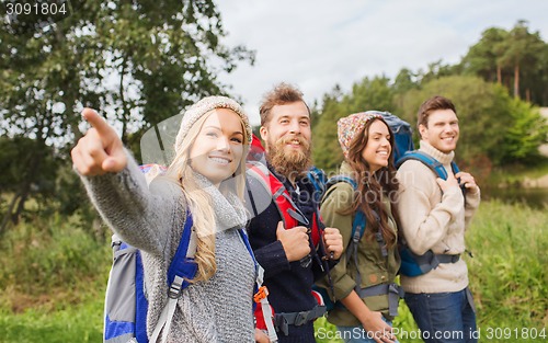 Image of group of smiling friends with backpacks hiking